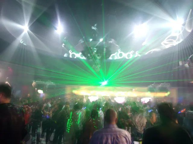 A dance-floor crowd lit by green lasers