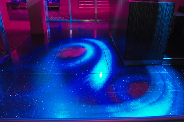 Blue and magenta lights across a dance floor