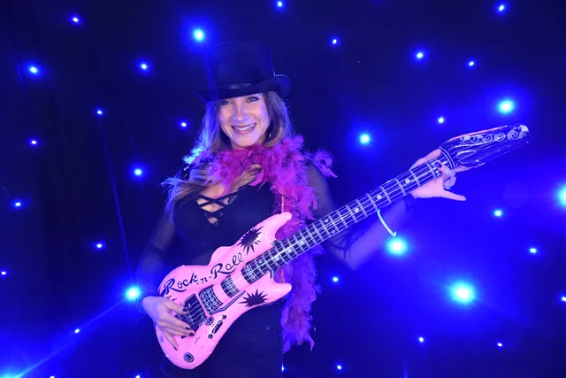 A guitarist performing under blue stage lights